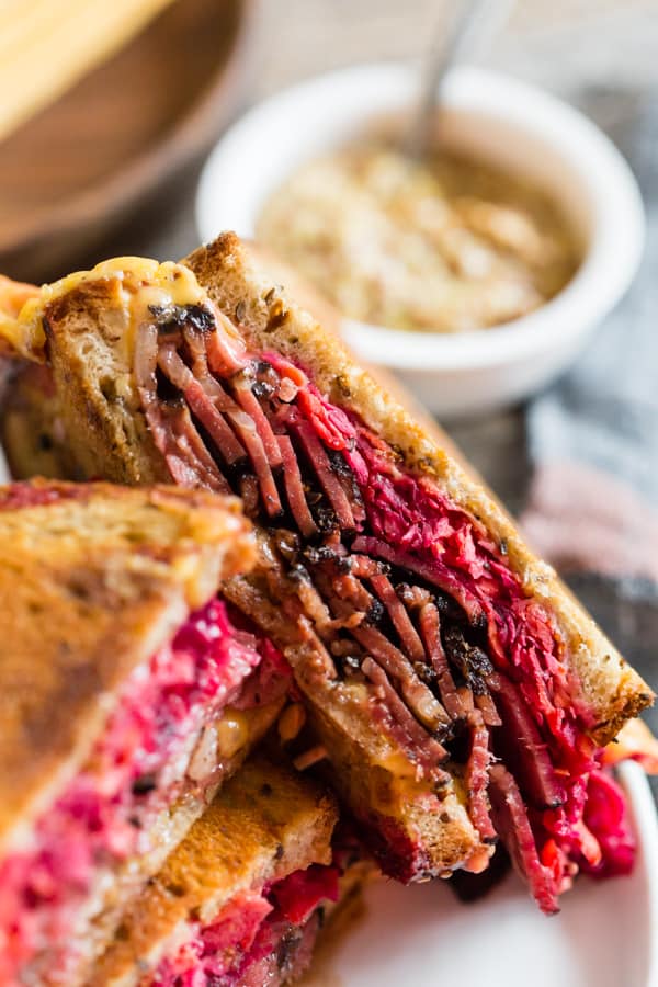 Grilled Pastrami Sandwich with Root Vegetable Slaw cut in half. 