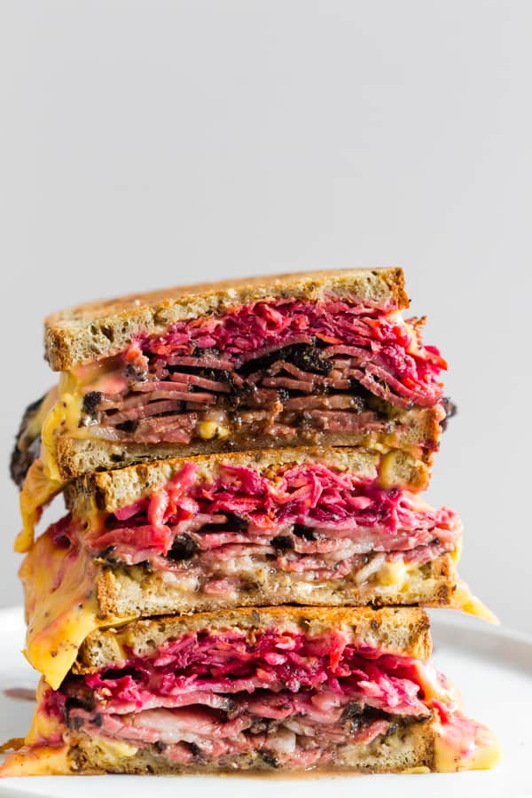 Grilled Pastrami Sandwich with Root Vegetable Slaw stacked on top of each other. 