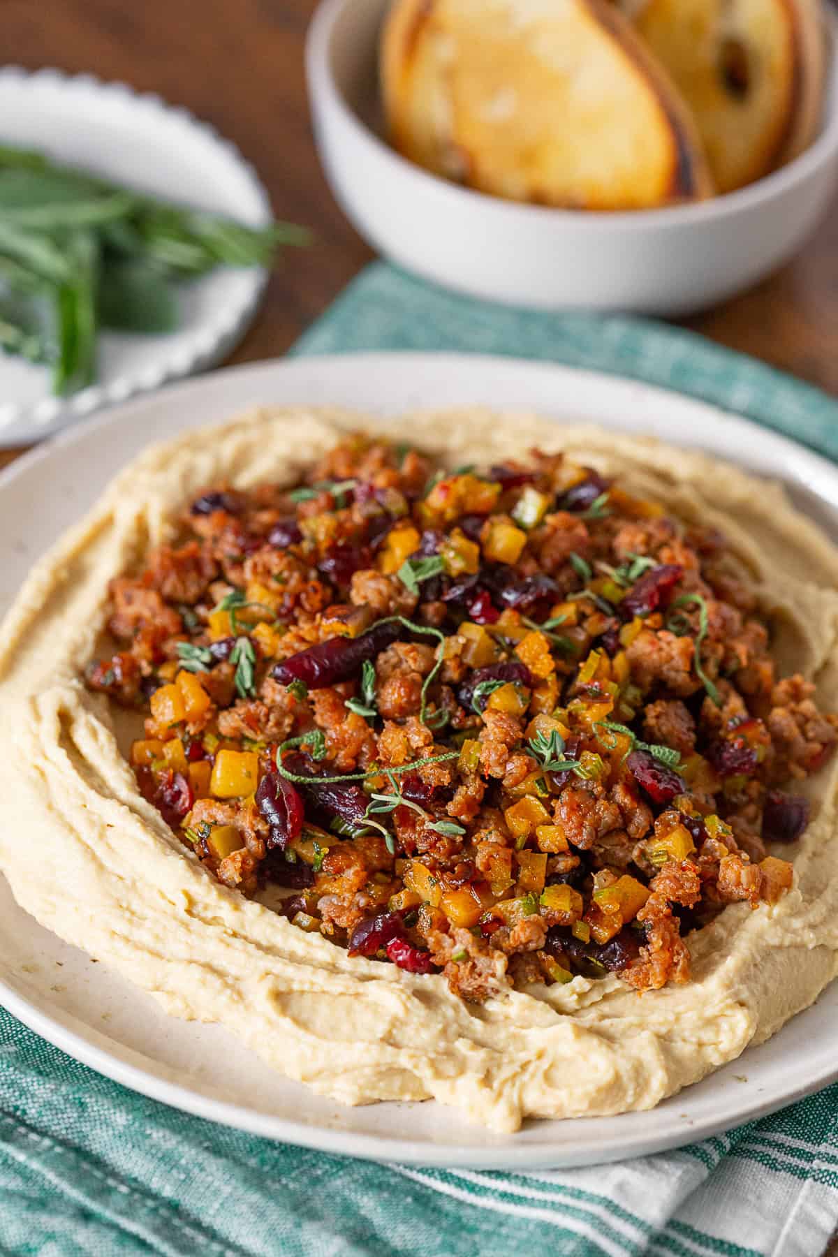 Thanksgiving Stuffing Topped Hummus on a plate with bread in the background