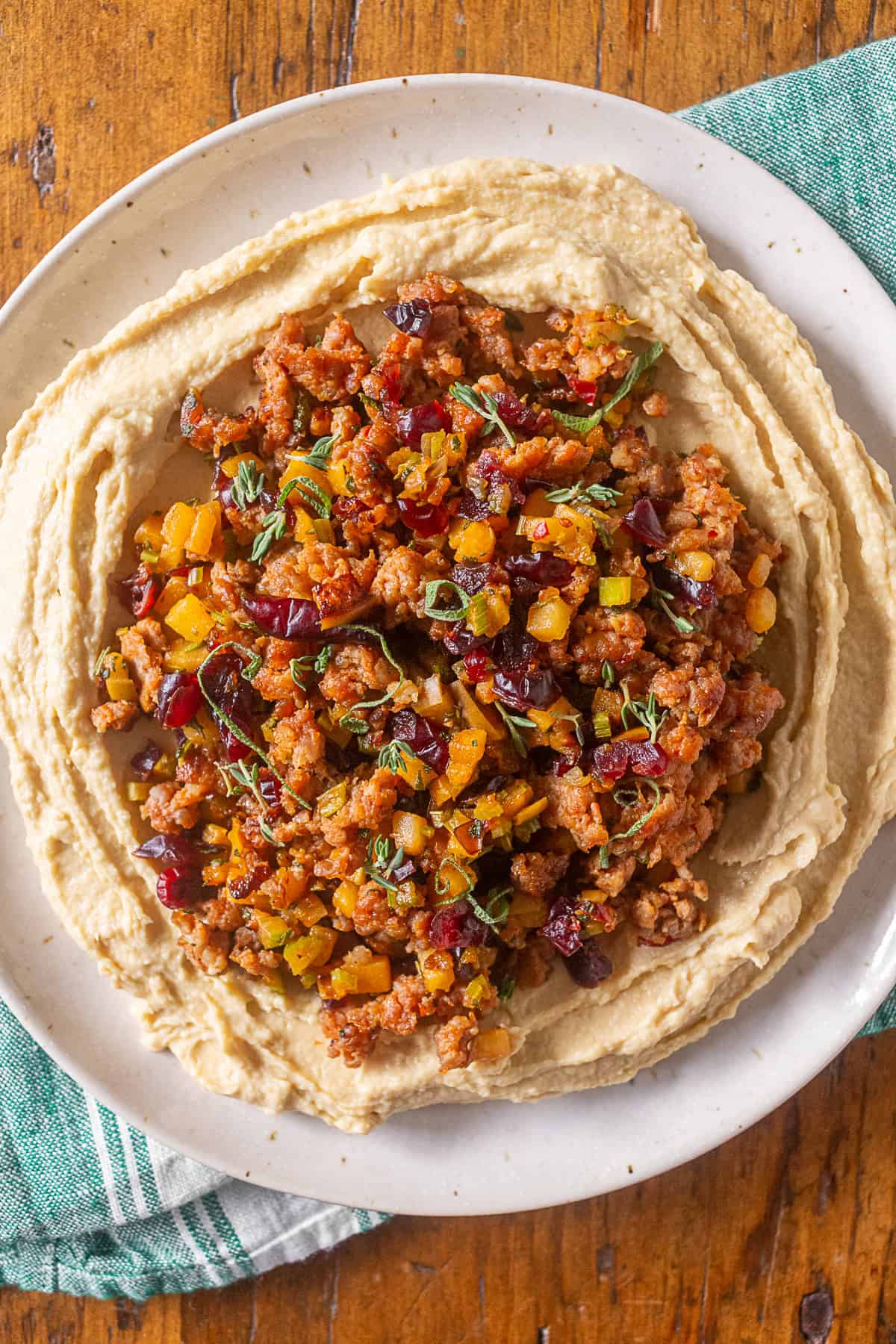 Thanksgiving stuffing topped hummus on a white plate