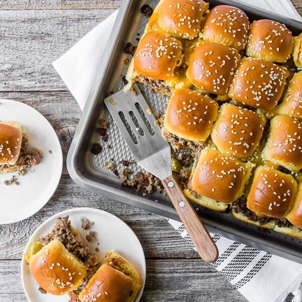 baked bacon cheeseburger sliders on a sheet pan and plate