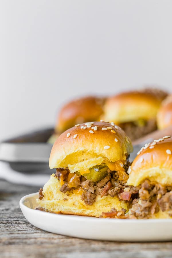 closeup of baked bacon cheeseburger sliders