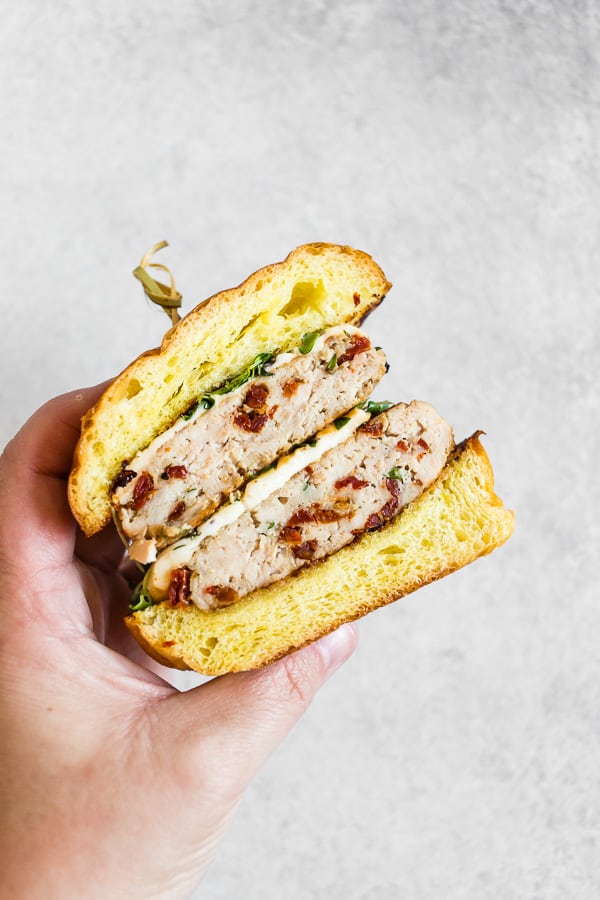 hand holding a sun dried tomato chicken burgers