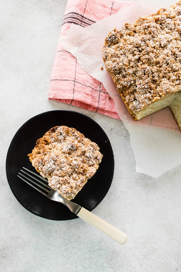 sourdough discard cinnamon crumb cake sliced on a black plate with a fork