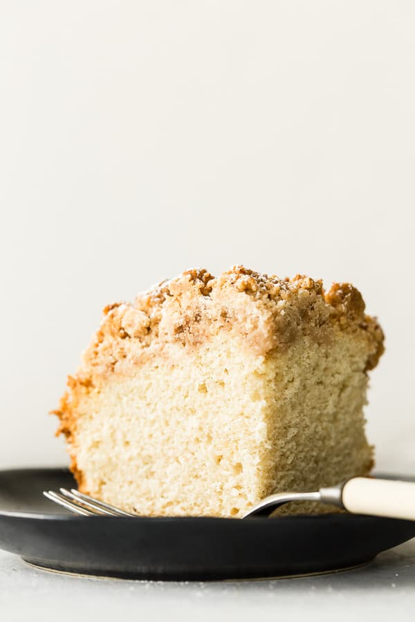 sourdough discard cinnamon crumb cake sliced on a black plate with a fork