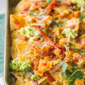 sweet chili chicken nachos topped with avocado and cilantro