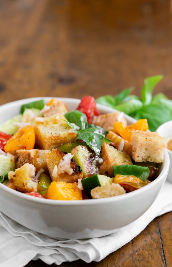 grilled sourdough panzanella salad in a white bowl