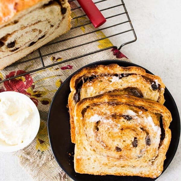 sliced cinnamon raisin sourdough bread on a plate with butter