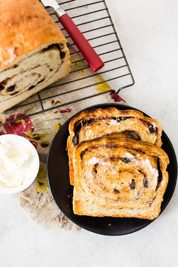 toasted cinnamon raisin sourdough bread on a plate with butter
