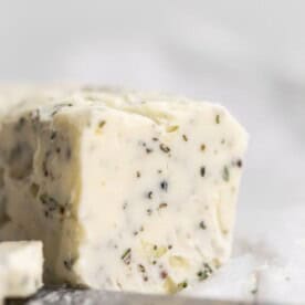 garlic herb compound butter sitting on parchment paper