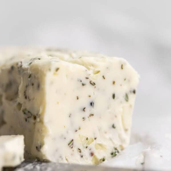 garlic herb compound butter sitting on parchment paper