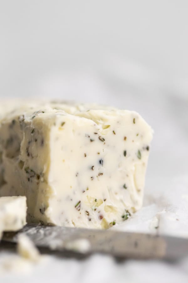 garlic herb compound butter sitting on parchment paper