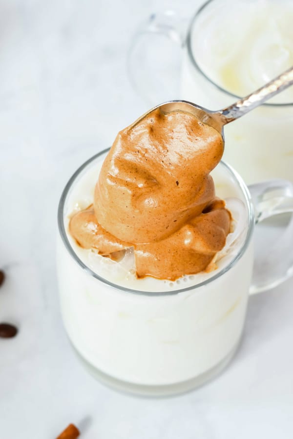adding the pumpkin spice whipped coffee to a mug