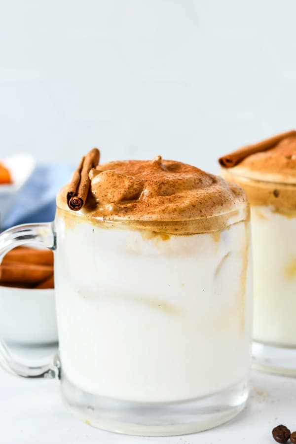 a glass mug filled with pumpkin spice whipped coffee