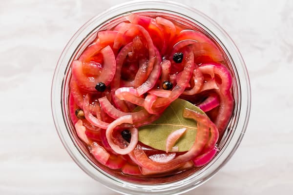 overhead shot of pickled red onions in small glass jar