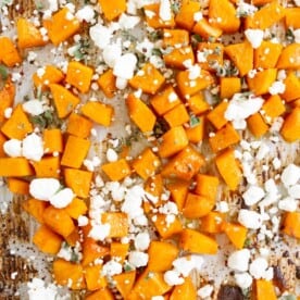 honey roasted butternut squash sprinkled with goat cheese on a sheetpan