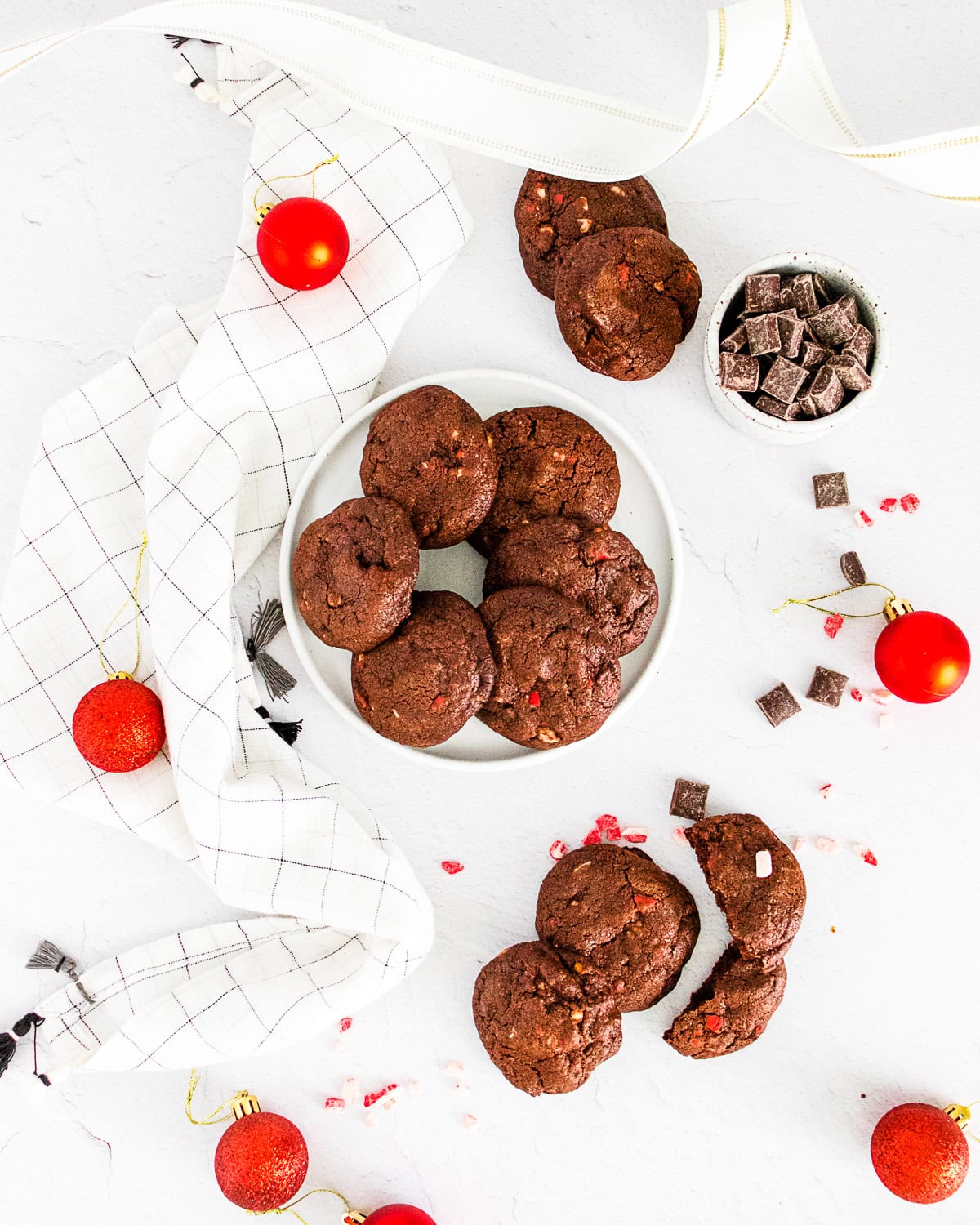 chocolate peppermint bark cookies on a white table surround by chocolate chips