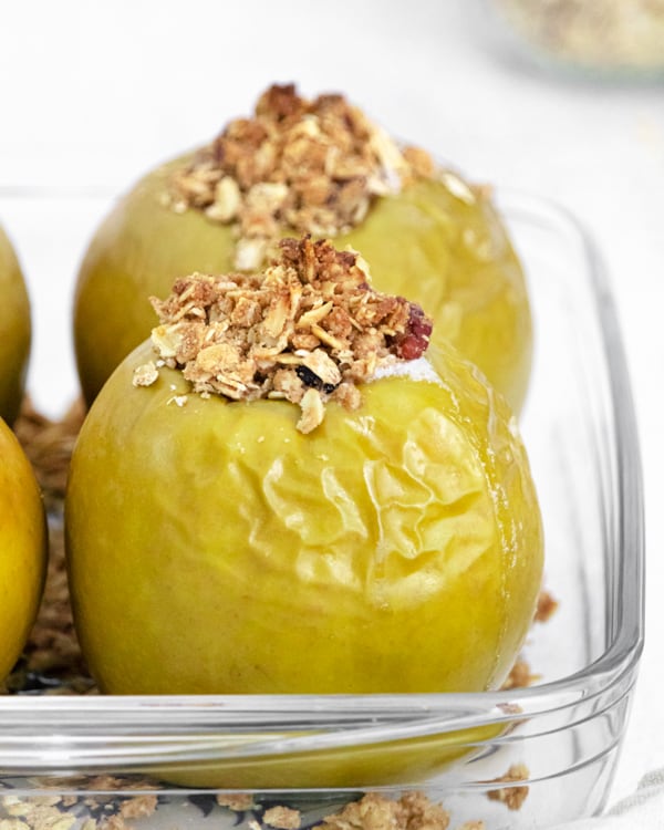 oatmeal stuffed breakfast baked apples in a clear serving dish.