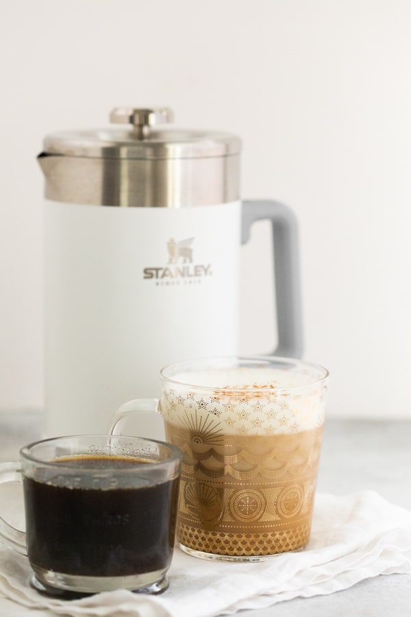 homemade cinnamon dolce syrup in a glass jar with a cup of coffee 