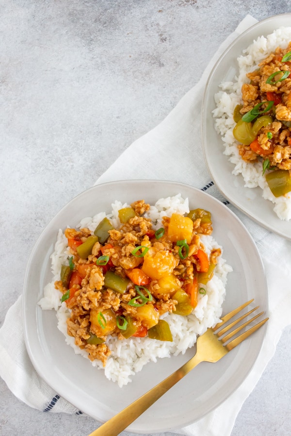 sweet and sour ground chicken on a plate with a fork