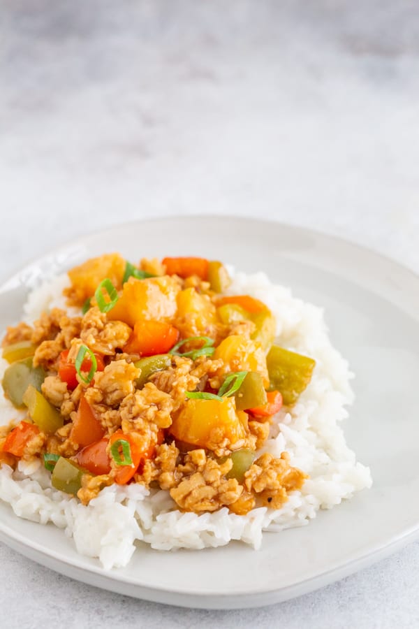sweet and sour ground chicken on an off white plate