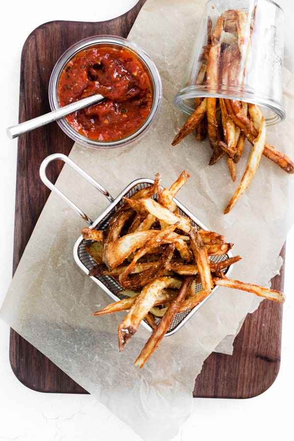 Garlic Parmesan Air Fryer French Fries on a table with ketchup