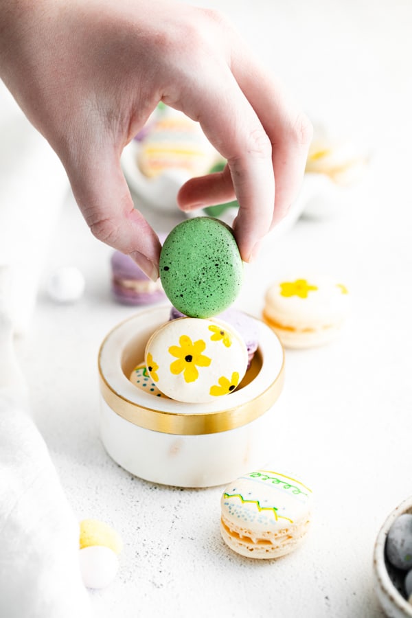 Holding a green easter egg macaron