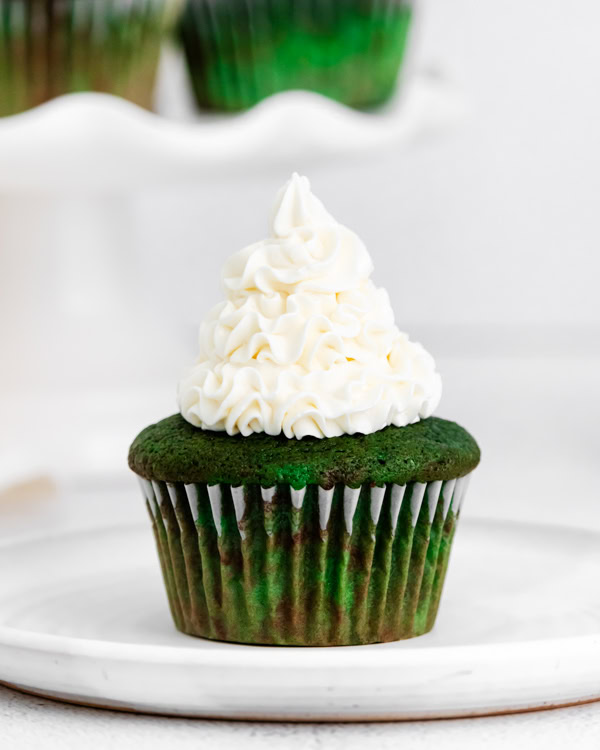 green velvet cupcake topped with vanilla frosting.