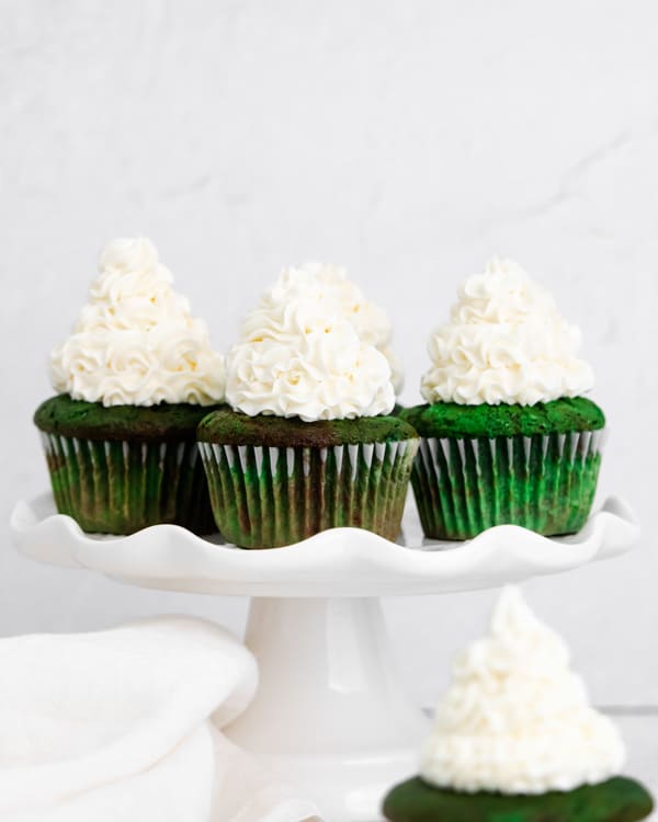 green velvet cupcakes on a cake plate.