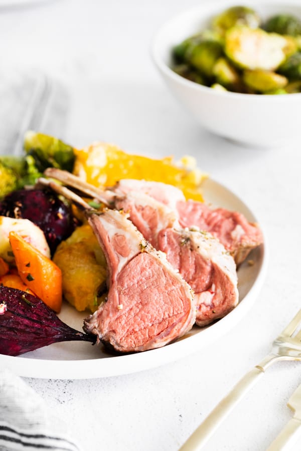 rare roasted lamb chops on a white plate.