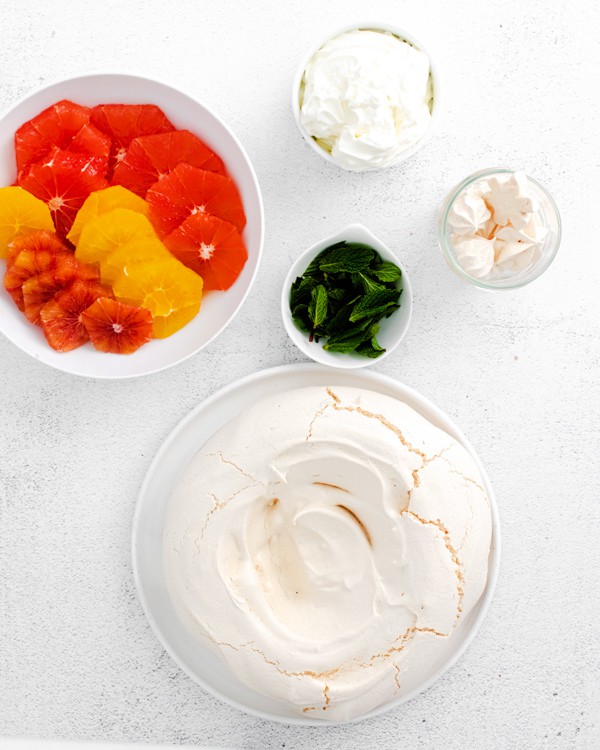 ingredients to make winter citrus pavlova on a board. 