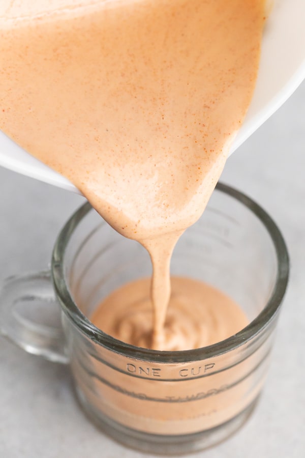 homemade fry sauce being poured into a serving glass.