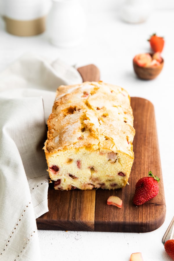 strawberry rhubarb pound cake on a serving board with fresh berries.