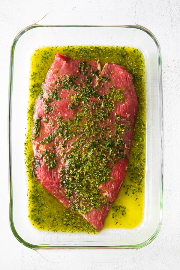 flank steak marinating in chimichurri sauce. 