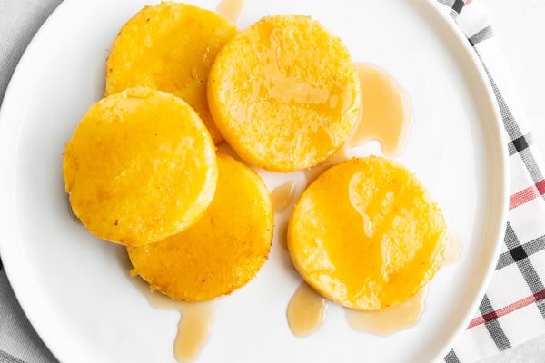 fried cornmeal mush on a white plate. 