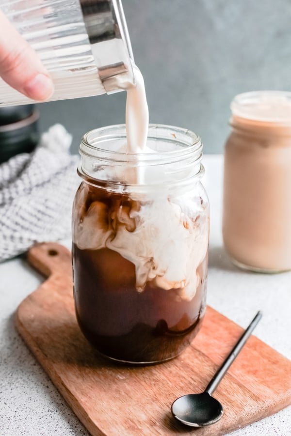 oat milk being poured into a shaken espresso.