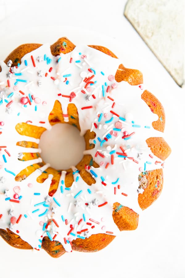 Fourth of July Bundt Cake topped with vanilla glaze and sprinkles.