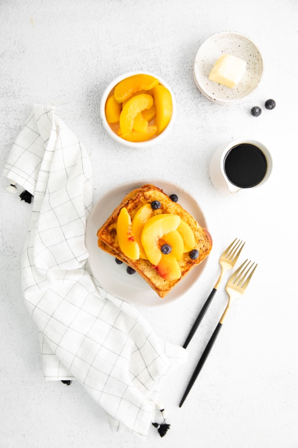 Peach Topped French Toast on a white plate with forks.