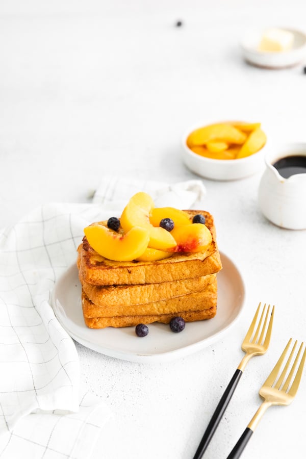 Peach Topped French Toast stacked on a plate.