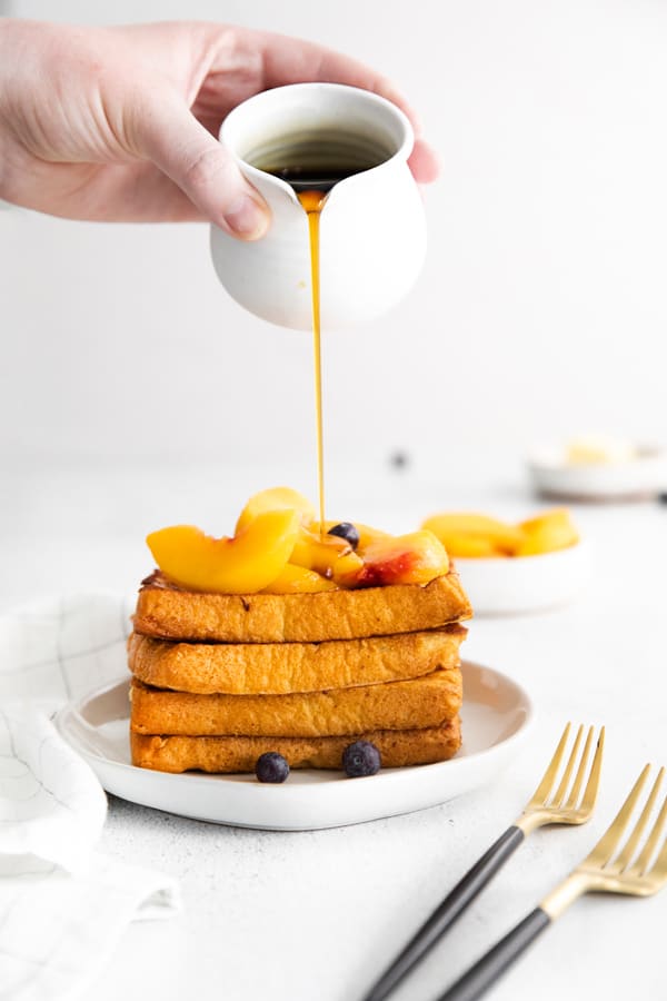 Peach Topped French Toast getting topped with syrup.
