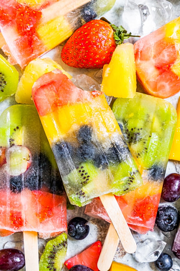 rainbow fruit popsicle with a bite taken out of it.