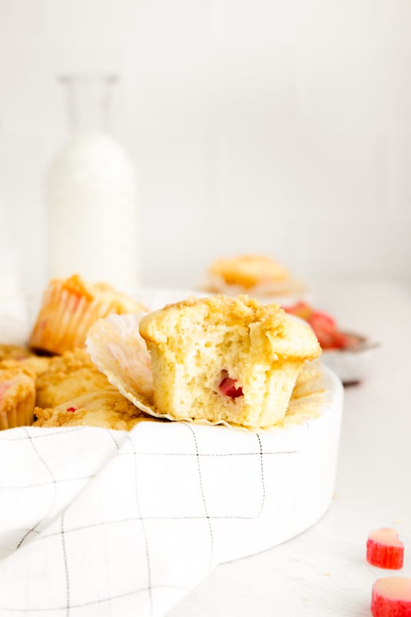 streusel topped rhubarb muffins with a bite taken out of the muffin. 