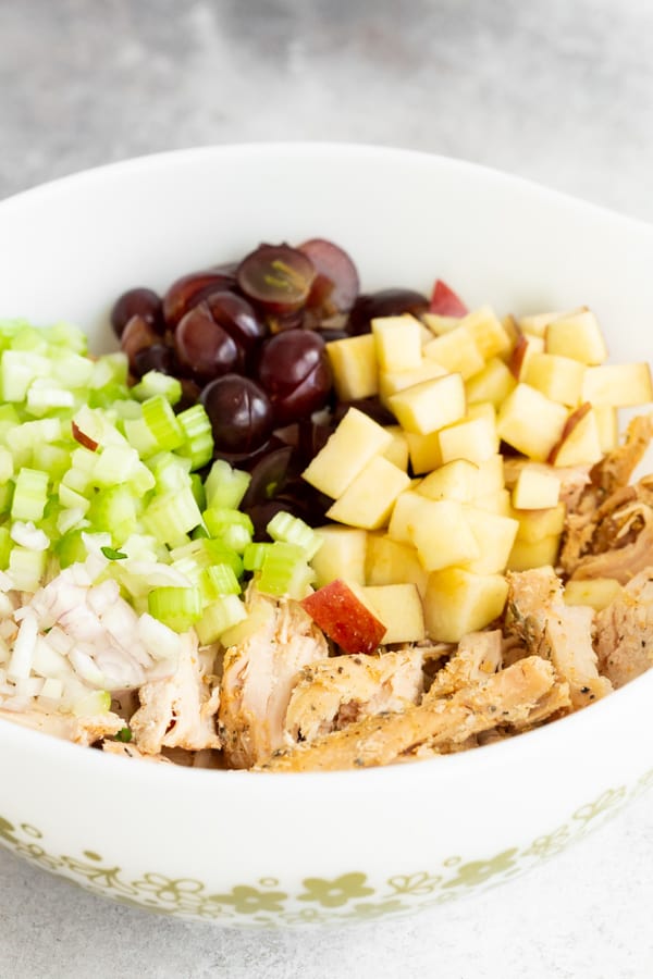 ingredients for the best chicken salad in a bowl waiting to be stirred together.