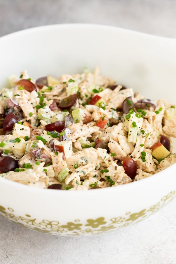 the best chicken salad stirred in a a mixing bowl.