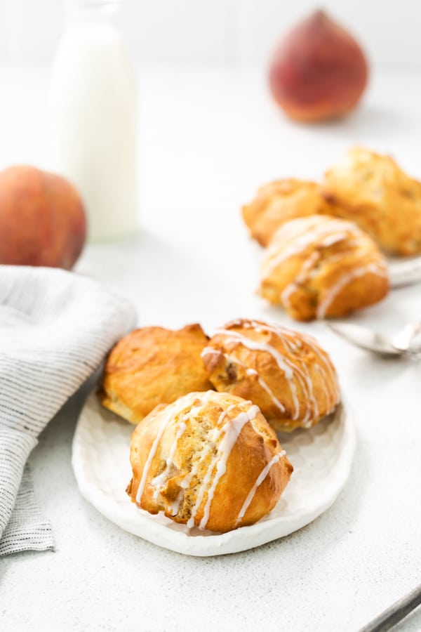 air fryer peach fritters sitting on a white plate. 