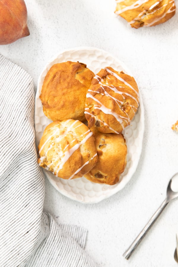 air fryer peach fritters drizzled with vanilla glaze.