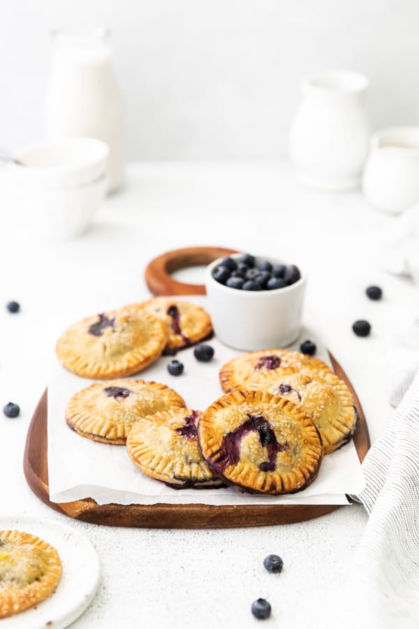 Easy Blueberry Hand Pies on a serving platter served with fresh blueberries. 
