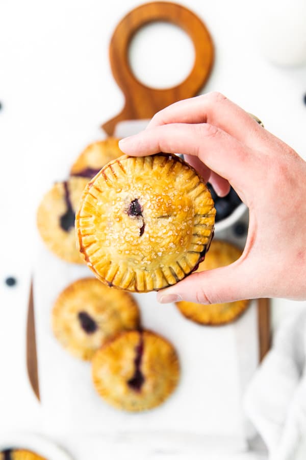 A hand holding an Easy Blueberry Hand Pie.