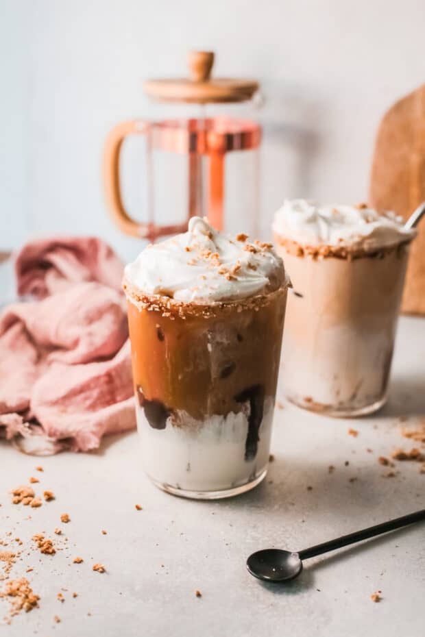 S'mores Iced Coffee in 2 glasses topped with marshmallow fluff.