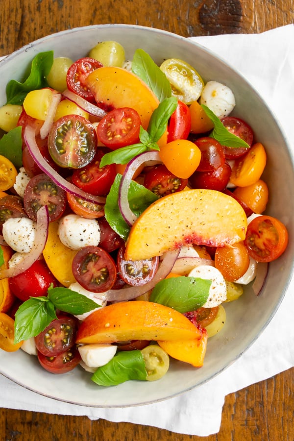 tomato peach Caprese salad in a bowl.